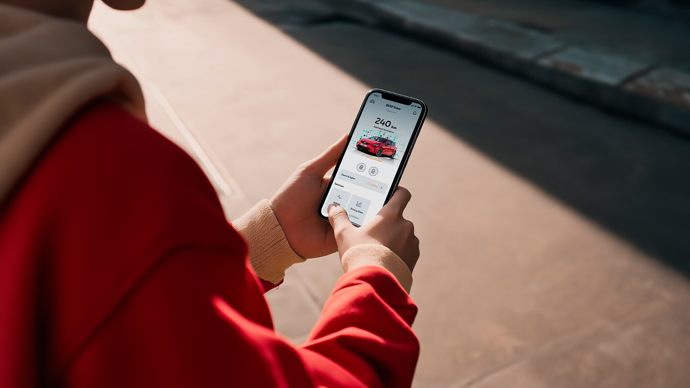 Person holding their smartphone checking seat connect system.