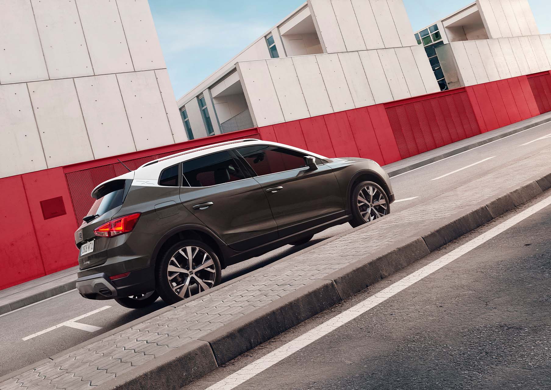 side view of the SEAT Arona xperience trim in cliff grey with white roof parked on the street