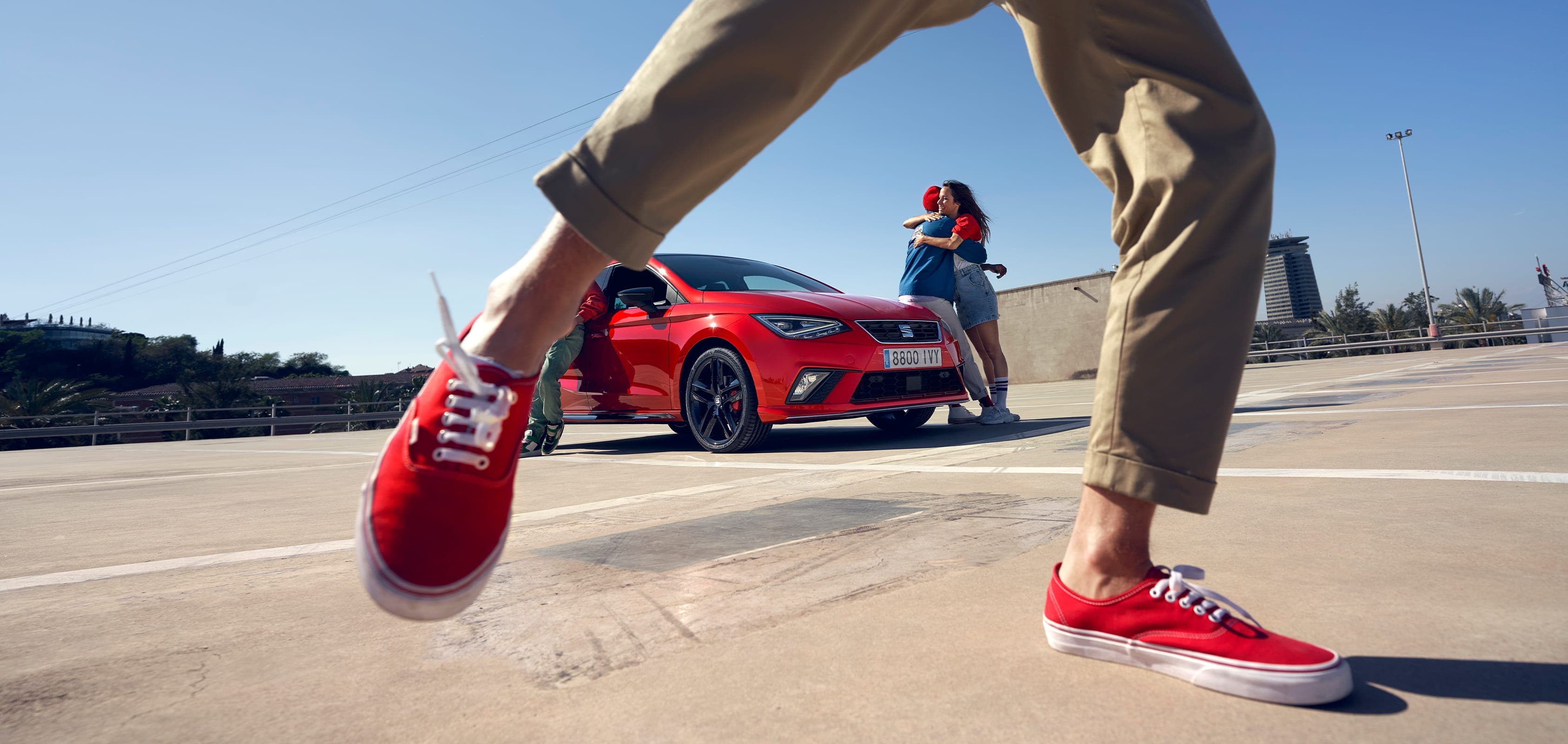 Man, dancing in front of SEAT Ibiza desire red colour  and couple hugging