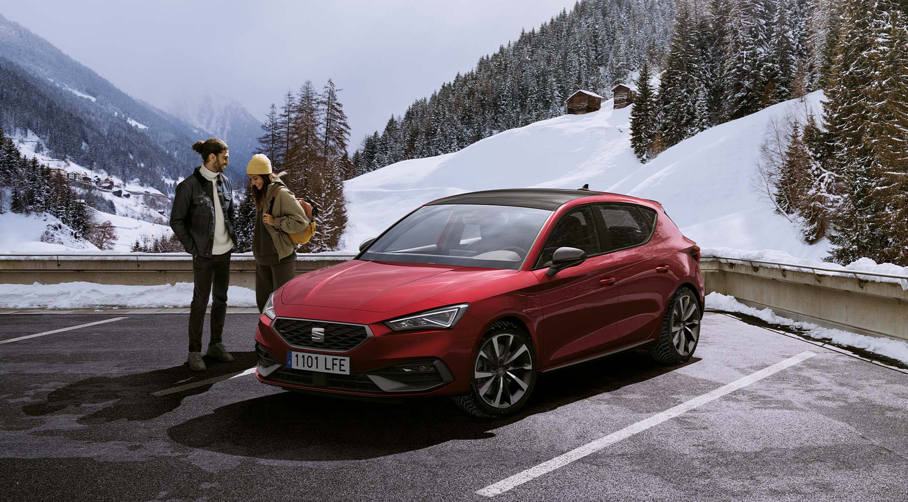 End of life car, seat leon in desire red ready to be recycled for car parts, models in a car park by the snow mountains and trees.