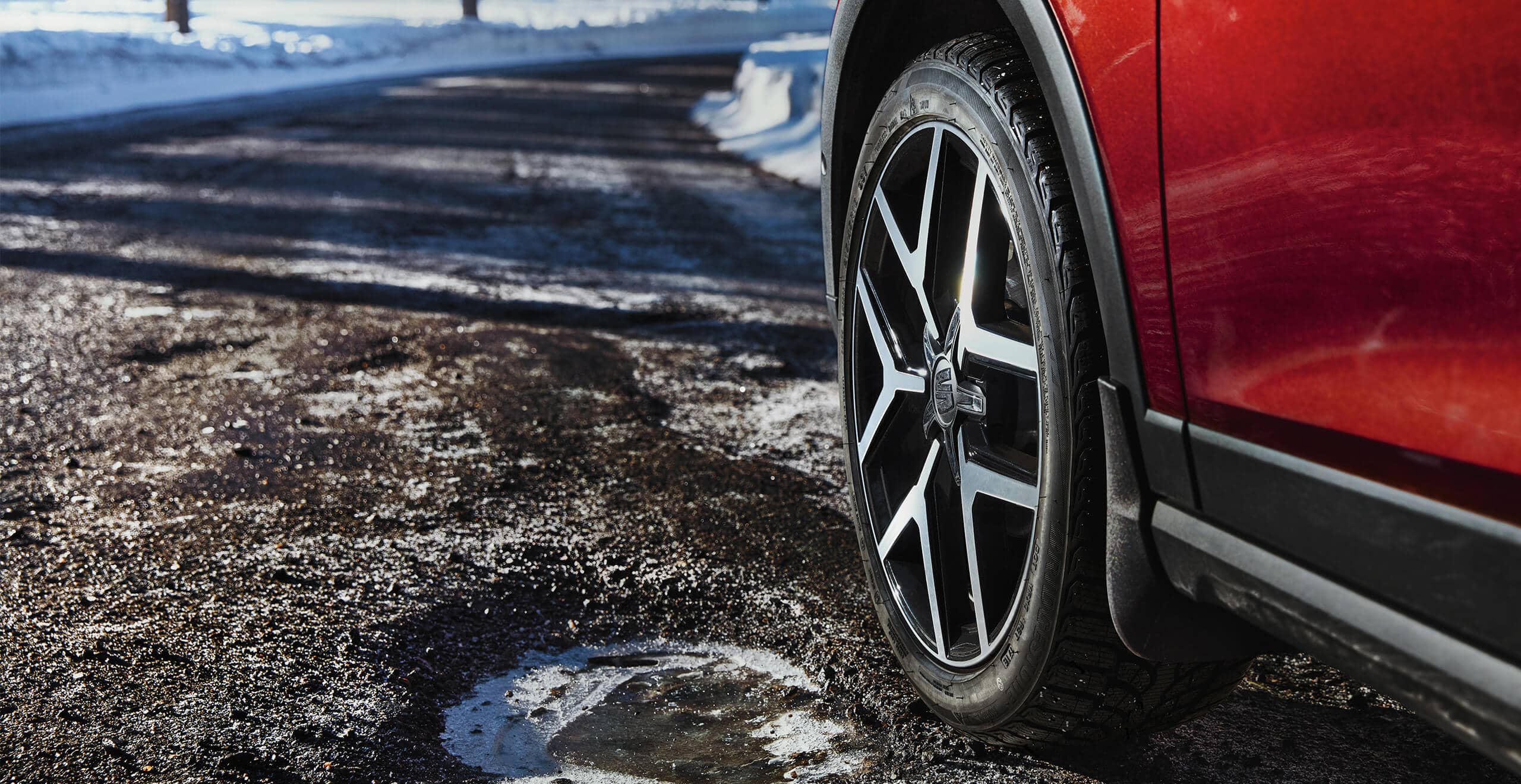 SEAT new car services roadside assistance maintenance – low view of the front left wheel of a red SEAT new car