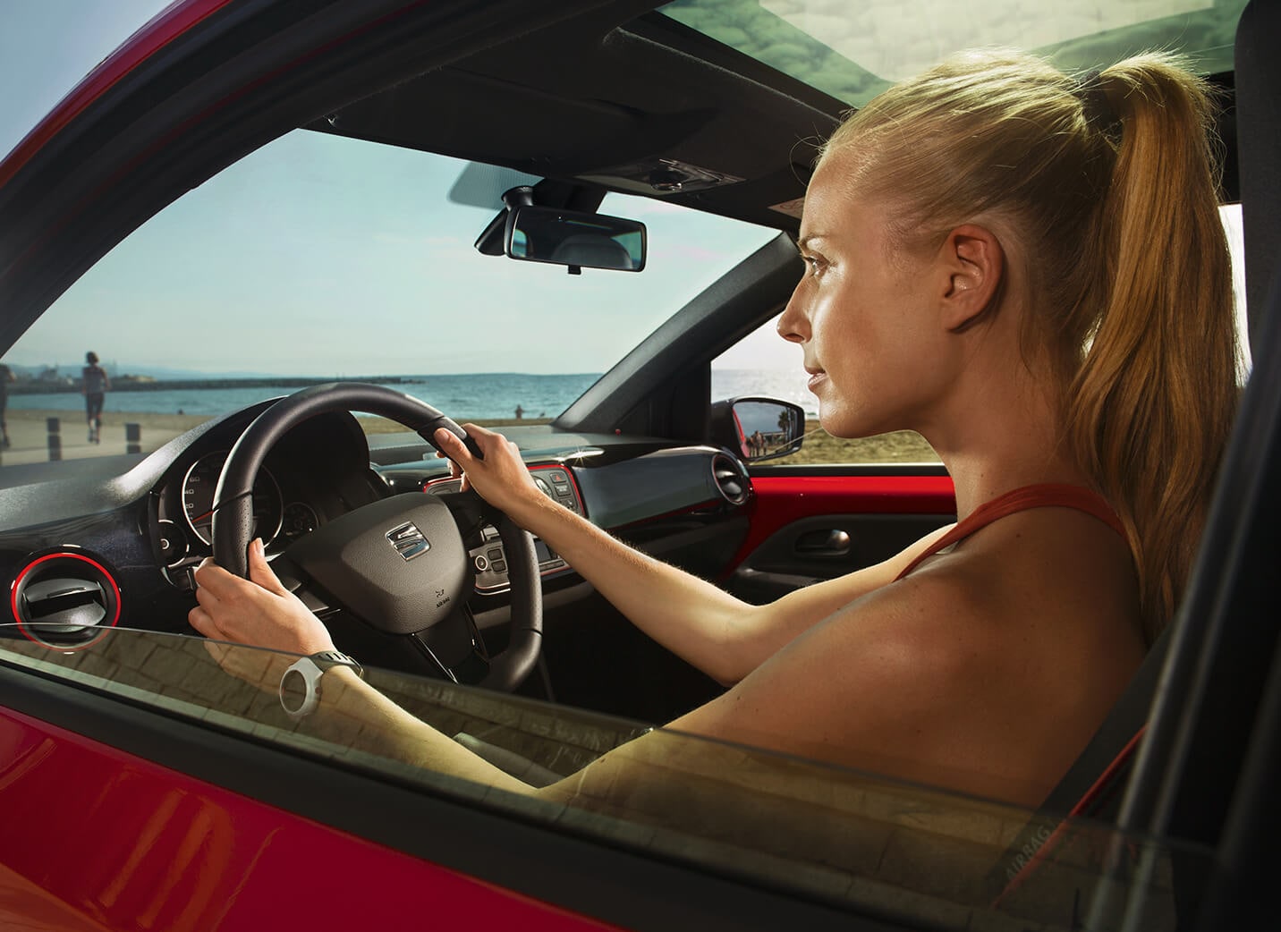 SEAT new car services and maintenance – Side view of woman driving a red new car SEAT